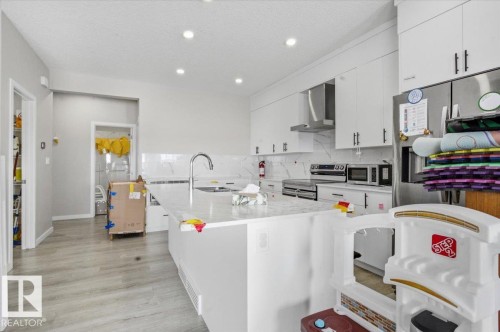 Contemporary kitchen featuring an oversized island with an undermount sink and a gooseneck faucet - 7056 182 Avenue, Edmonton, AB - Indoor Photo Showing Kitchen