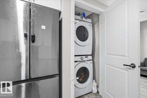 White paneled door opening to a stacked laundry unit - 7056 182 Avenue, Edmonton, AB - Indoor Photo Showing Laundry Room