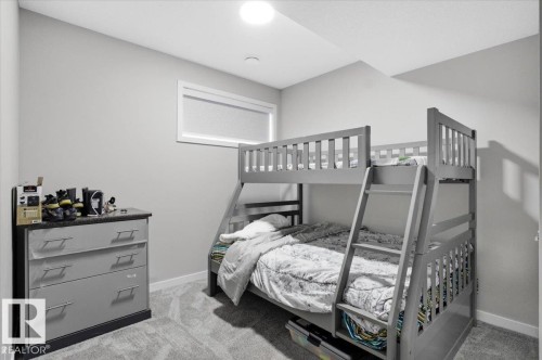 Carpeted room featuring light gray walls, a flush-mount ceiling light, and a horizontal window with a privacy blind - 7056 182 Avenue, Edmonton, AB - Indoor Photo Showing Bedroom