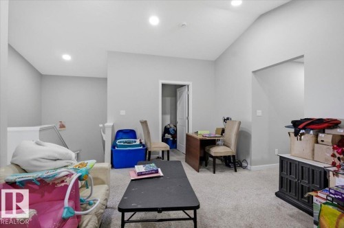 Spacious room featuring vaulted ceilings, light gray wall paint, recessed lighting, and carpeted flooring - 7056 182 Avenue, Edmonton, AB - Indoor