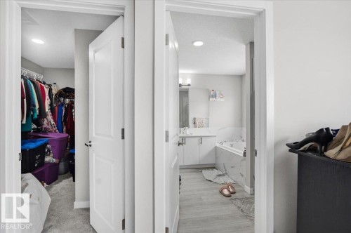 Bathroom featuring a white vanity with an undermount sink, quartz countertop, and a built-in tub with a tile surround - 7056 182 Avenue, Edmonton, AB - Indoor Photo Showing Bathroom