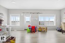 Spacious room featuring light wood-finish flooring, light gray walls, and white trim - 7056 182 Avenue, Edmonton, AB  - Indoor 