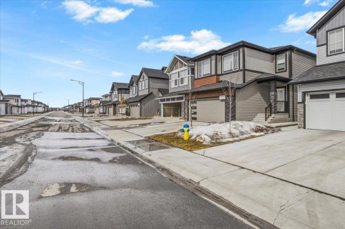 Contemporary residential streetscape featuring two-story homes with attached garages - 7056 182 Avenue, Edmonton, AB - Outdoor With Facade
