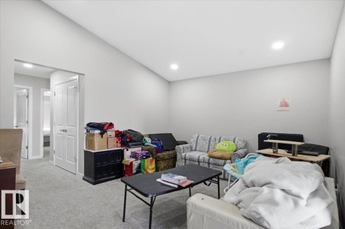 Recessed lighting illuminates this room, featuring light gray walls, white trim, and gray carpeted flooring - 7056 182 Avenue, Edmonton, AB - Indoor