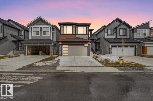 Contemporary home exterior featuring a multi-tone facade with stone accents and horizontal siding - 7056 182 Avenue, Edmonton, AB - Outdoor With Facade
