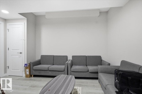 Recessed lighting illuminating a spacious room with light gray walls and wood-finish flooring - 7056 182 Avenue, Edmonton, AB - Indoor Photo Showing Living Room