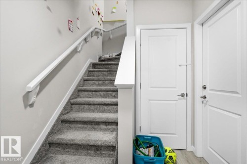 Carpeted staircase with white handrail and baseboards - 7056 182 Avenue, Edmonton, AB - Indoor Photo Showing Other Room