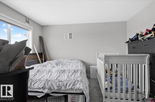 Room featuring light gray painted walls, a large window, and gray carpeted flooring - 7056 182 Avenue, Edmonton, AB - Indoor Photo Showing Bedroom