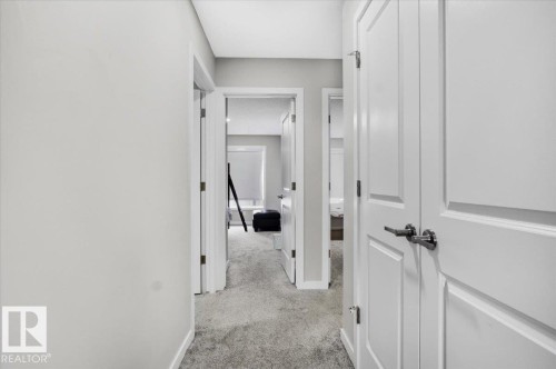 Interior hallway with light gray walls, textured gray carpeting, and white trim - 7056 182 Avenue, Edmonton, AB - Indoor Photo Showing Other Room