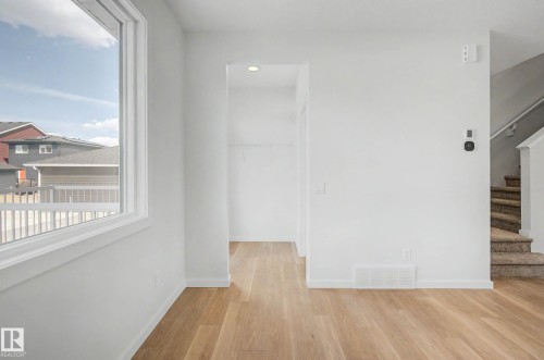 Bright interior featuring wood-finish flooring and crisp white walls - 720 Southfork Drive, Leduc, AB - Indoor Photo Showing Other Room