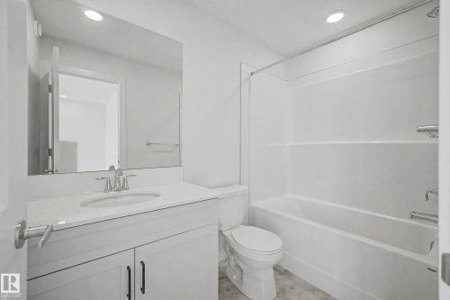 Bathroom featuring a white vanity with a light-toned countertop, a rectangular undermount sink, and a chrome faucet - 720 Southfork Drive, Leduc, AB - Indoor Photo Showing Bathroom