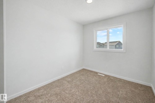 Bright interior space featuring a window with white trim, recessed lighting, neutral carpeting, and white baseboards - 720 Southfork Drive, Leduc, AB - Indoor Photo Showing Other Room