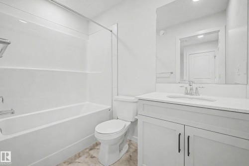 Full bathroom featuring a white tub and shower combination with chrome fixtures, a white toilet, and a vanity with a light-colored countertop - 720 Southfork Drive, Leduc, AB - Indoor Photo Showing Bathroom