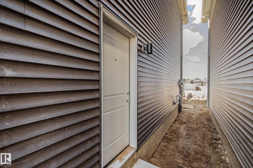 Exterior door with paneling set into horizontal siding - 720 Southfork Drive, Leduc, AB -  With Exterior