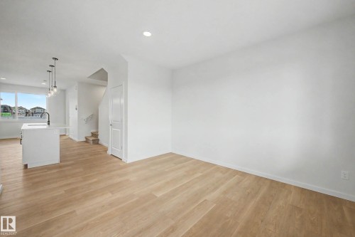 Bright open-concept living area featuring light wood-finish flooring, recessed lighting, and white baseboards - 720 Southfork Drive, Leduc, AB - Indoor Photo Showing Other Room