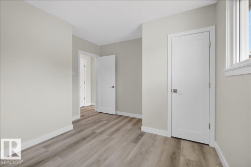 Room featuring light wood-finish flooring, light grey painted walls, white trim, and a white single-pane window - 9723 65 Avenue, Edmonton, AB - Indoor Photo Showing Other Room