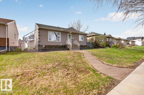 Single-story residence featuring a stucco exterior with decorative quoins, multiple windows, and a raised entry with steps and railings - 9723 65 Avenue, Edmonton, AB - Outdoor