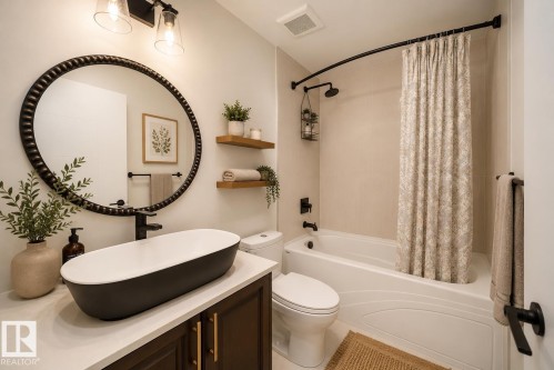 Contemporary bathroom featuring a vessel sink with matte black fixtures, a dark wood-finish vanity with gold hardware, and a tub with an overhead shower - 126 Harrison Drive, Edmonton, AB - Indoor Photo Showing Bathroom