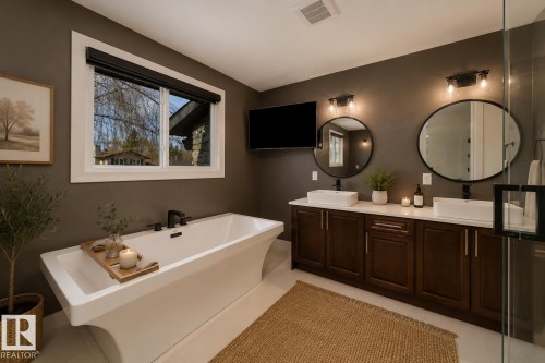 Freestanding soaking tub with matte black fixtures - 126 Harrison Drive, Edmonton, AB - Indoor Photo Showing Bathroom