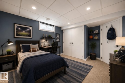 Carpeted room featuring a white grid-pattern ceiling with recessed lighting, a built-in window with blind, and two white bi-fold doors - 126 Harrison Drive, Edmonton, AB - Indoor Photo Showing Bedroom