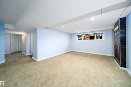 Spacious room featuring light blue walls, neutral carpet flooring, and a window with exterior visibility - 126 Harrison Drive, Edmonton, AB - Indoor