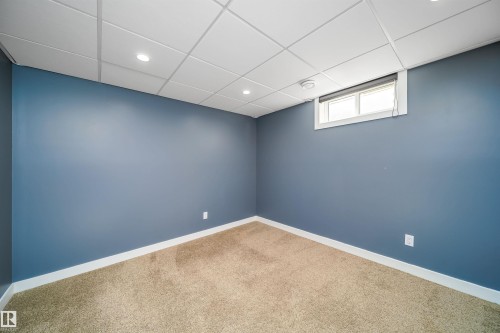 Room featuring blue walls, light brown carpet, and a white grid ceiling with recessed lighting - 126 Harrison Drive, Edmonton, AB - Indoor Photo Showing Other Room