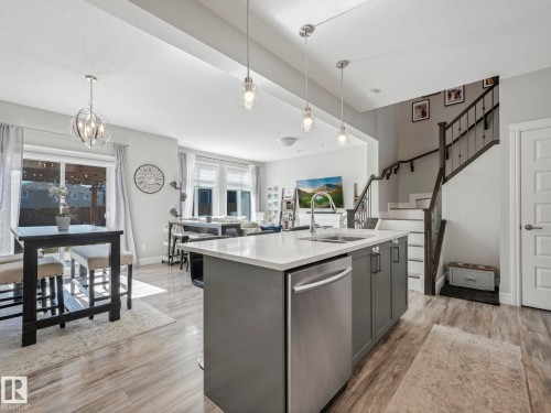 Kitchen island with a stainless steel dishwasher, undermount sink, and white countertop - 3817 Robins Crescent, Edmonton, AB - Indoor Photo Showing Kitchen