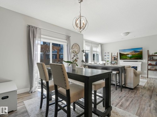 Open-concept living area featuring wood-finish flooring, recessed lighting, and a contemporary spherical chandelier - 3817 Robins Crescent, Edmonton, AB - Indoor Photo Showing Dining Room