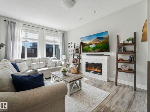 Living area featuring wide plank wood-finish flooring - 3817 Robins Crescent, Edmonton, AB - Indoor Photo Showing Living Room With Fireplace