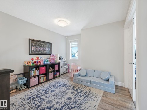Versatile room featuring neutral wall tones, wood-finish flooring, and a window with a white blind - 3817 Robins Crescent, Edmonton, AB - Indoor Photo Showing Living Room