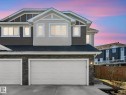 Contemporary multi-story exterior featuring a two-car garage, stacked stone accents, horizontal siding, and multiple windows with white trim - 3817 Robins Crescent, Edmonton, AB  - Outdoor 