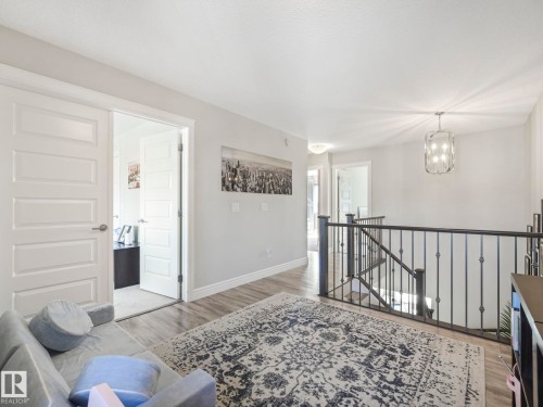 Hallway with wood-finish flooring, white trim, and light gray walls - 3817 Robins Crescent, Edmonton, AB - Indoor Photo Showing Other Room