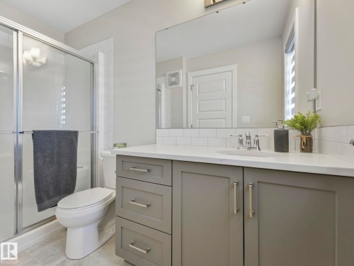 Bathroom featuring a gray vanity with an integrated sink, polished chrome faucet, and white countertop - 3817 Robins Crescent, Edmonton, AB - Indoor Photo Showing Bathroom