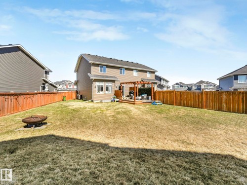 Expansive backyard featuring a large wooden deck with pergola, privacy fencing, and a built-in fire pit - 3817 Robins Crescent, Edmonton, AB - Outdoor