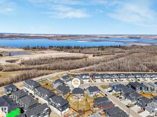 Aerial perspective showcasing a residential development with a prominent body of water in the background - 3817 Robins Crescent, Edmonton, AB - Outdoor With Body Of Water With View