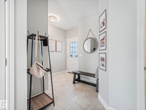 Entryway featuring light-toned tile flooring, light gray wall paint, and a front door with glass windowpanes - 3817 Robins Crescent, Edmonton, AB - Indoor Photo Showing Other Room