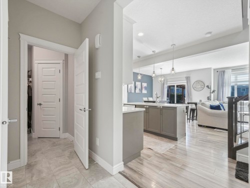 Light wood-finish flooring extending into an open-concept living area - 3817 Robins Crescent, Edmonton, AB - Indoor