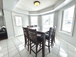 Dining room featuring light tile patterned floors, a textured ceiling, and a raised ceiling - 