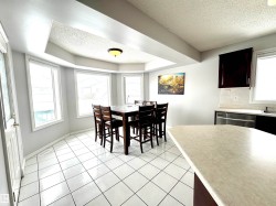 Dining space featuring a textured ceiling, light tile patterned floors, and a raised ceiling - 