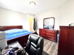 Bedroom featuring light wood finished floors and a textured ceiling - 