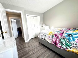 Bedroom featuring a textured ceiling, dark wood finished floors, and a closet - 