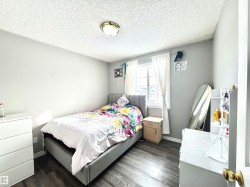 Bedroom with dark wood-style flooring and a textured ceiling - 