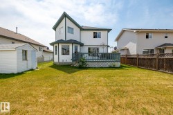 Rear view of house featuring a deck, a fenced backyard, and a shed - 