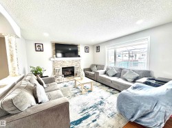 Living room featuring a fireplace, recessed lighting, a textured ceiling, and wood finished floors - 