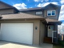 Exterior featuring a multi-paneled garage door, horizontal siding, and a gabled roofline - 4914 47 Street, Redwater, AB  - Outdoor 