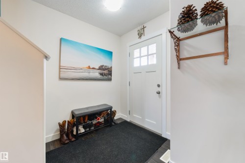 Entryway featuring a white paneled door with windowpanes, dark wood-finish flooring, and light neutral walls - 4914 47 Street, Redwater, AB - Indoor Photo Showing Other Room