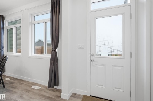 Entryway featuring a white door with a frosted glass panel, a transom window, and light wood-style flooring - 4047 Hawthorn Link Link, Edmonton, AB - Indoor Photo Showing Other Room