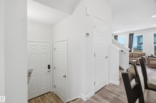 The property features an entryway with a white paneled door and wood-style flooring - 4047 Hawthorn Link Link, Edmonton, AB - Indoor Photo Showing Other Room
