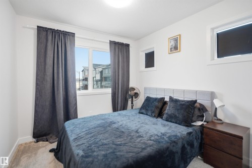 This room features white walls, a carpeted floor, and windows providing natural light - 4047 Hawthorn Link Link, Edmonton, AB - Indoor Photo Showing Bedroom