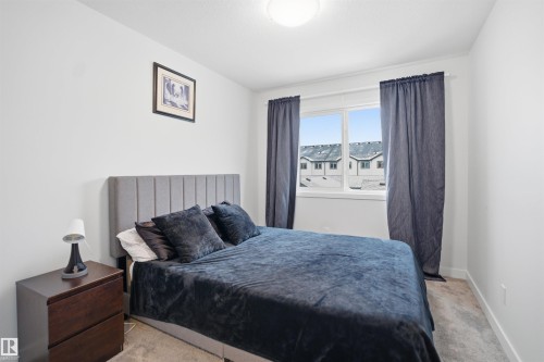 This room features light-colored walls and grey carpet, creating a bright and neutral palette - 4047 Hawthorn Link Link, Edmonton, AB - Indoor Photo Showing Bedroom